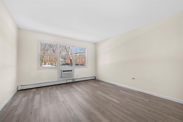 empty room featuring a baseboard radiator, light wood-style flooring, and baseboards