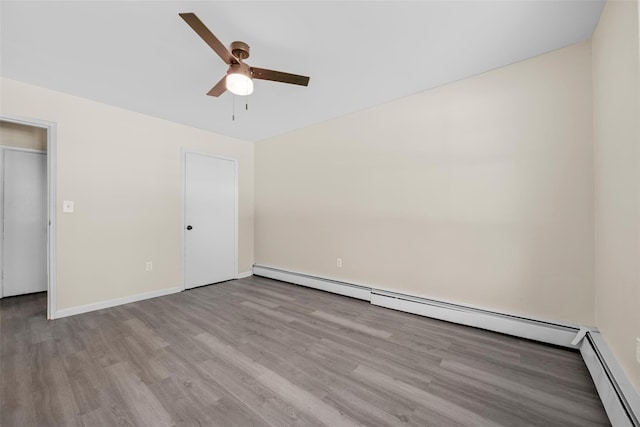 unfurnished bedroom with light wood finished floors, baseboards, a baseboard heating unit, and a ceiling fan