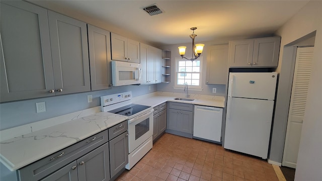 kitchen with white appliances, a sink, visible vents, open shelves, and an inviting chandelier