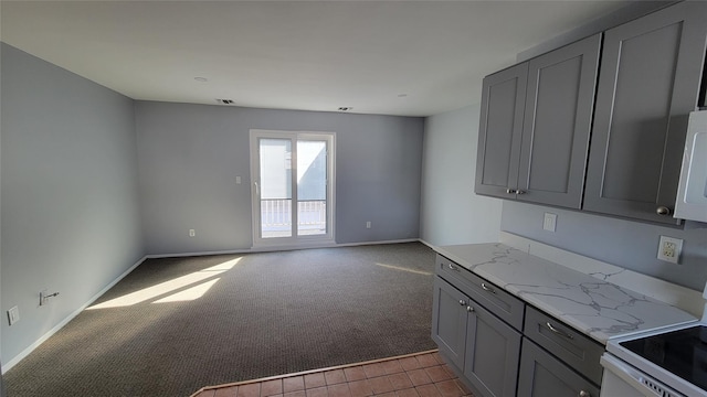 kitchen featuring light stone countertops, carpet flooring, gray cabinetry, and white electric range oven