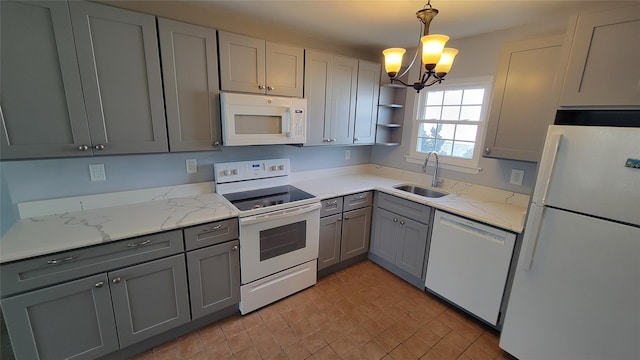 kitchen with white appliances, light stone countertops, gray cabinetry, open shelves, and a sink