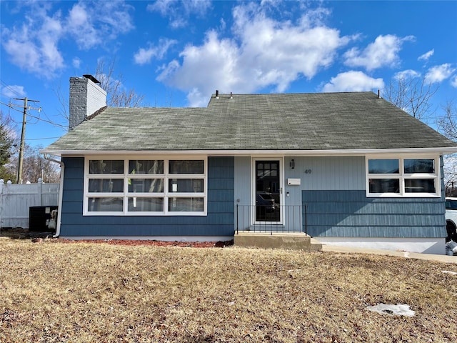 single story home featuring central AC, fence, and a chimney