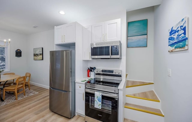 kitchen with appliances with stainless steel finishes, light wood-style floors, white cabinets, light countertops, and baseboards