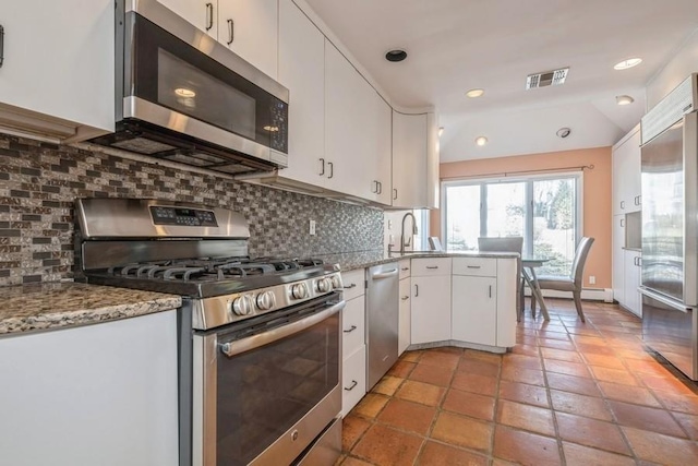 kitchen with visible vents, white cabinets, appliances with stainless steel finishes, light stone countertops, and backsplash