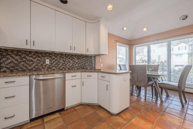 kitchen with backsplash, white cabinetry, a sink, dark stone countertops, and dishwasher