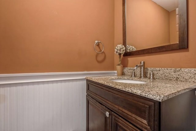 bathroom featuring a wainscoted wall and vanity