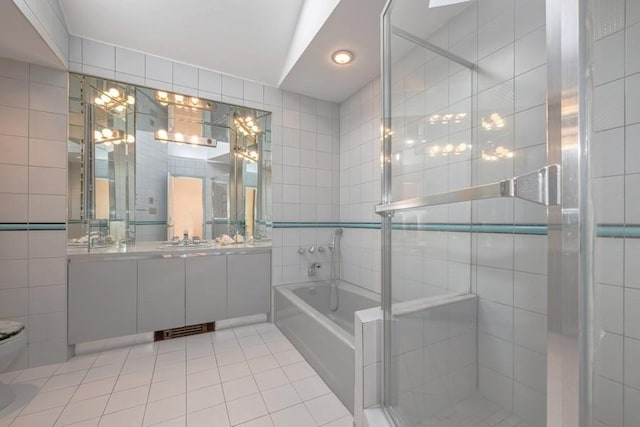 full bathroom featuring vanity, tile walls, a bath, tile patterned floors, and a stall shower