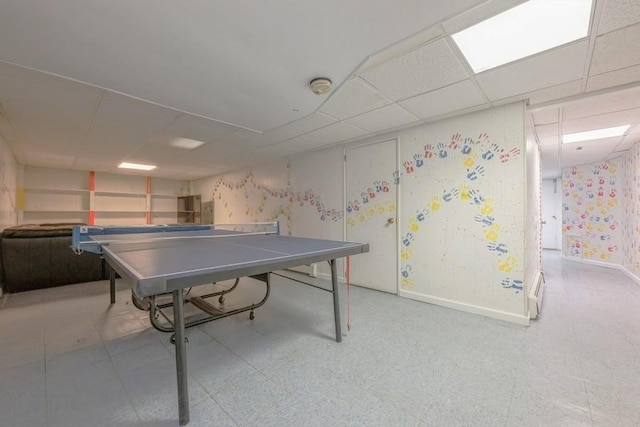 recreation room with a drop ceiling, baseboards, and tile patterned floors