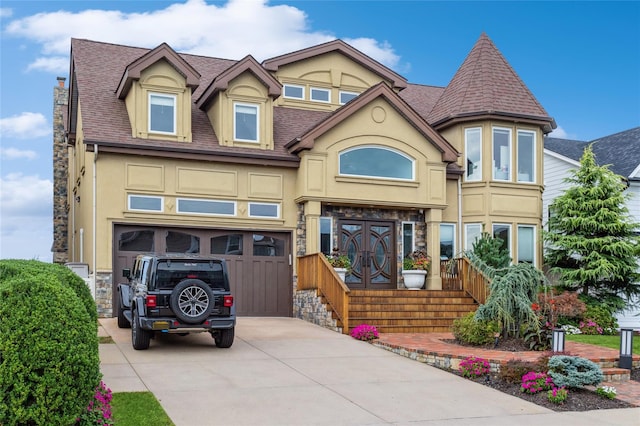 view of front of home with a garage, concrete driveway, stone siding, roof with shingles, and stucco siding