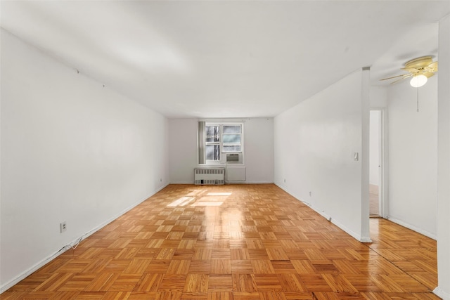 spare room with cooling unit, a ceiling fan, and radiator