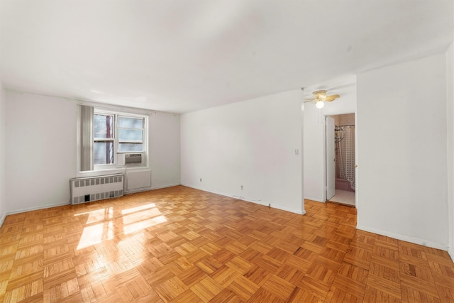 empty room featuring ceiling fan, radiator heating unit, cooling unit, and baseboards