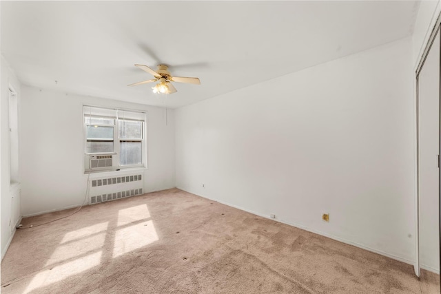 unfurnished room featuring carpet floors, cooling unit, radiator, and ceiling fan