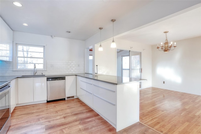 kitchen with stainless steel appliances, dark countertops, white cabinetry, and modern cabinets