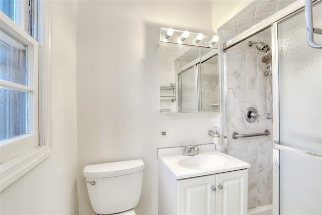 full bathroom with toilet, tiled shower, and vanity