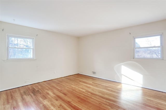 unfurnished room featuring light wood-type flooring and visible vents