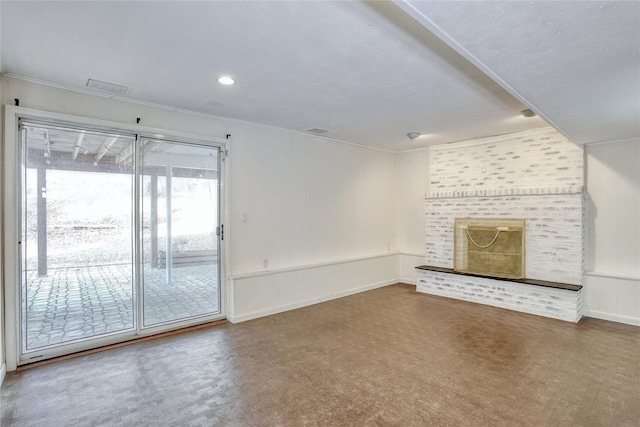 unfurnished living room with crown molding, visible vents, a fireplace, and baseboards