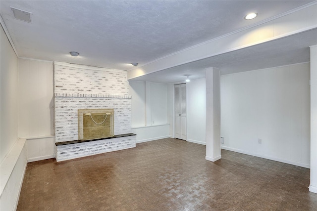 unfurnished living room featuring baseboards, visible vents, a textured ceiling, crown molding, and a brick fireplace