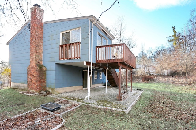 back of house featuring stairway, a chimney, a yard, and a deck