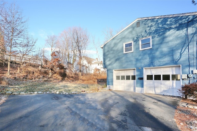 view of home's exterior featuring aphalt driveway and an attached garage