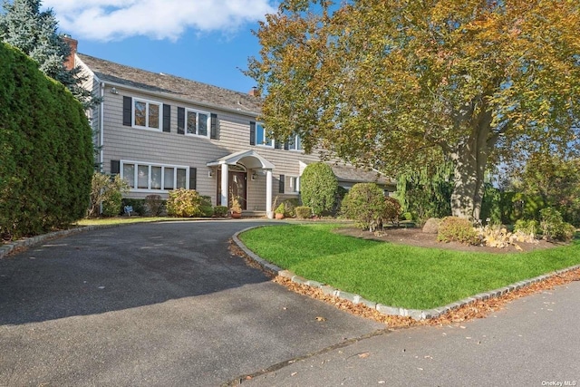 colonial inspired home featuring driveway and a front yard