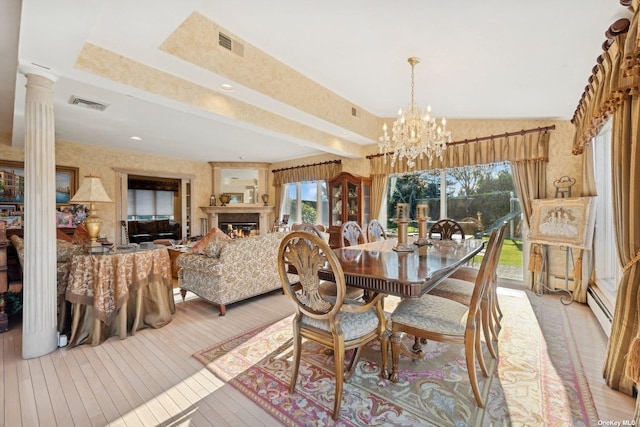 dining area featuring visible vents, plenty of natural light, a lit fireplace, and ornate columns