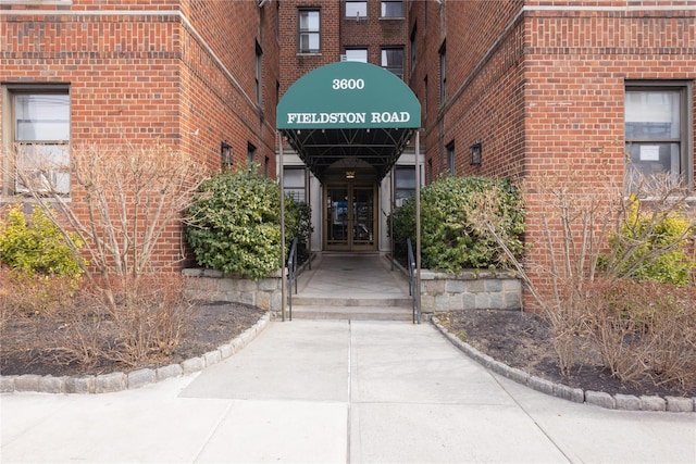 entrance to property featuring french doors and brick siding