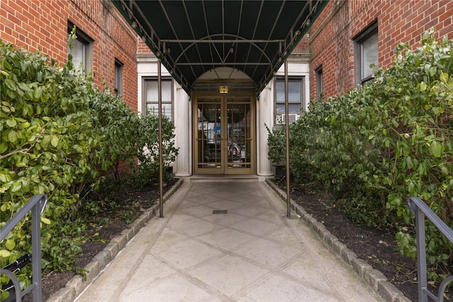 property entrance featuring french doors and brick siding