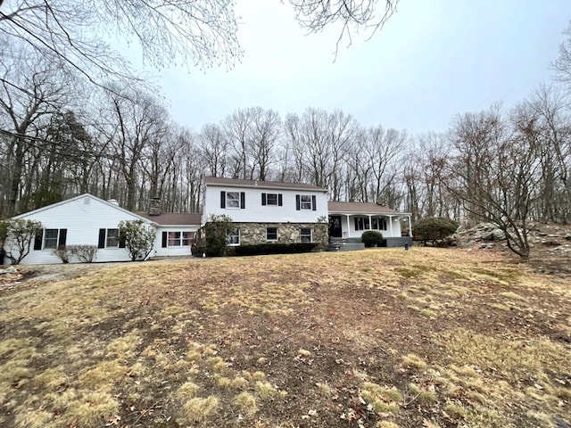 split level home with stone siding and a porch