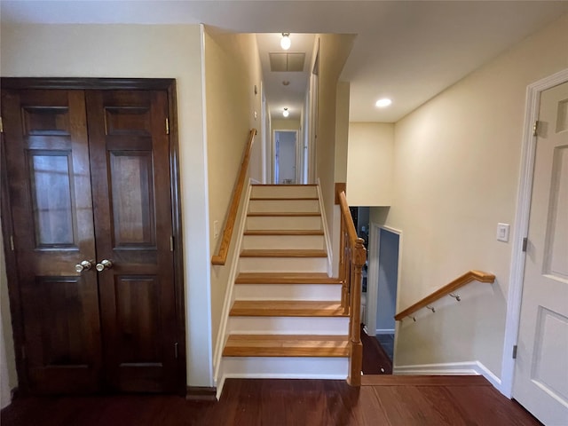 stairs featuring visible vents, wood finished floors, and baseboards