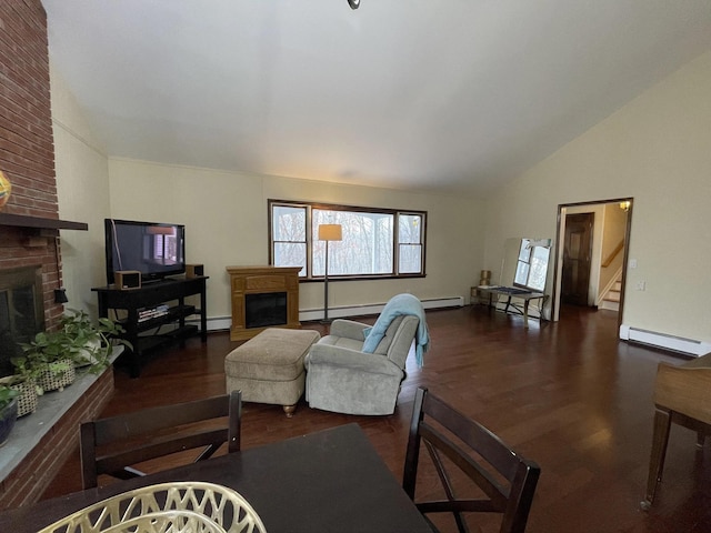 living area with wood finished floors, stairway, a baseboard radiator, lofted ceiling, and a brick fireplace