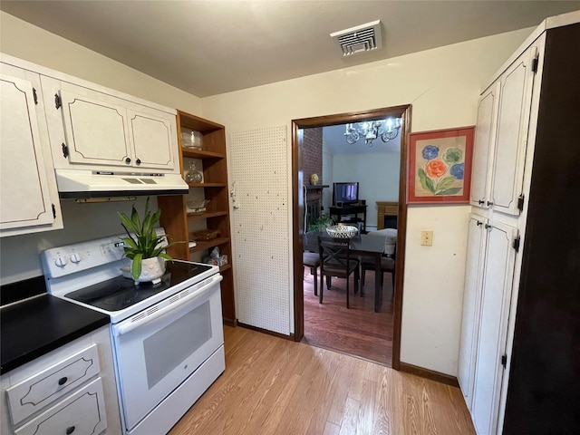 kitchen featuring white electric range oven, visible vents, light wood finished floors, under cabinet range hood, and a notable chandelier