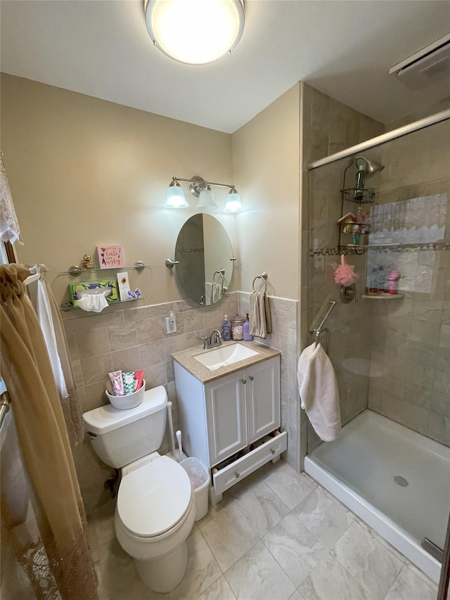 full bath featuring vanity, visible vents, tiled shower, tile walls, and toilet