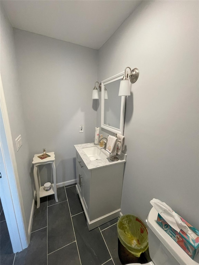 bathroom featuring baseboards, toilet, vanity, and tile patterned flooring