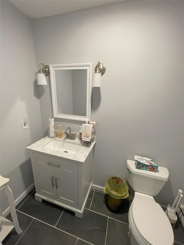 bathroom featuring vanity, toilet, baseboards, and tile patterned flooring