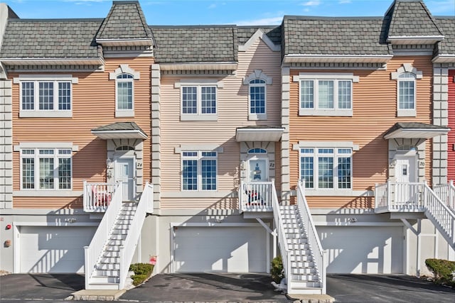 view of front of property featuring driveway, a garage, and mansard roof