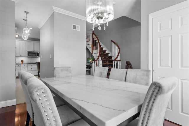 dining area featuring dark wood-style floors, a notable chandelier, visible vents, ornamental molding, and stairs