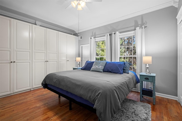 bedroom featuring visible vents, baseboards, a ceiling fan, hardwood / wood-style floors, and crown molding