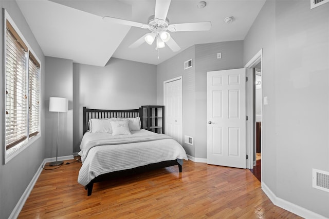 bedroom with visible vents, ceiling fan, baseboards, and wood finished floors