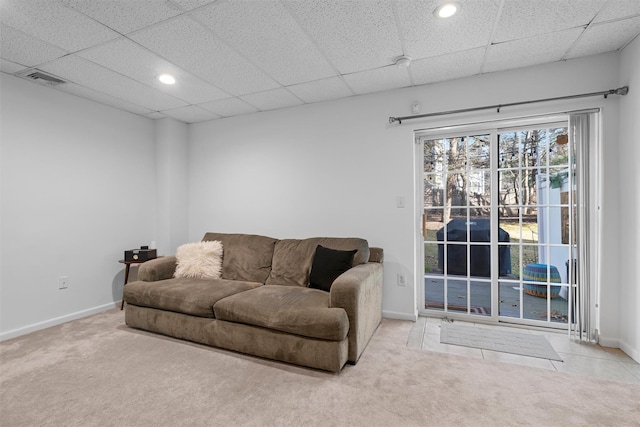 living area with a paneled ceiling, carpet flooring, visible vents, and baseboards