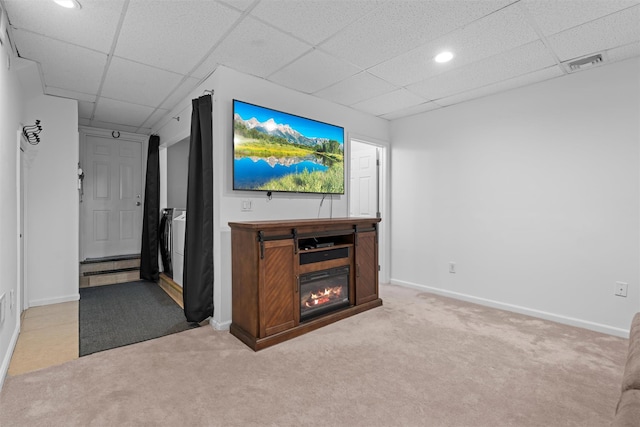 unfurnished living room with baseboards, a paneled ceiling, visible vents, and light colored carpet