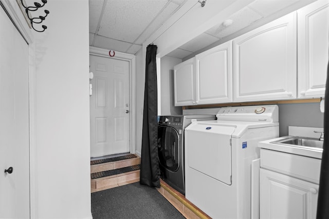 clothes washing area featuring cabinet space and separate washer and dryer