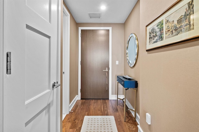 doorway with visible vents, dark wood finished floors, and baseboards