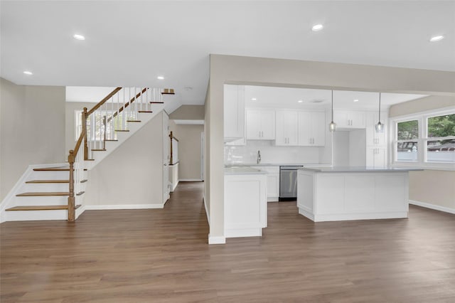 kitchen featuring dark wood-type flooring, white cabinetry, light countertops, a center island, and dishwasher