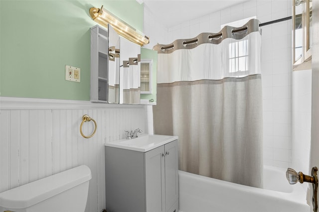 full bath with vanity, wainscoting, shower / bath combo with shower curtain, and toilet