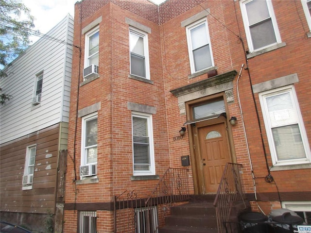 doorway to property with cooling unit and brick siding