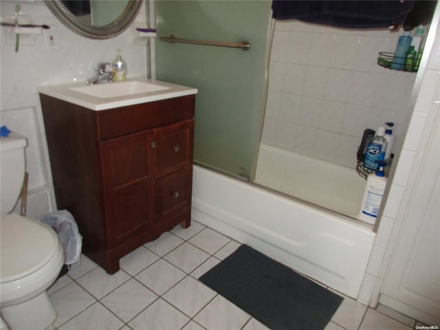 bathroom featuring combined bath / shower with glass door, toilet, tile patterned flooring, and vanity