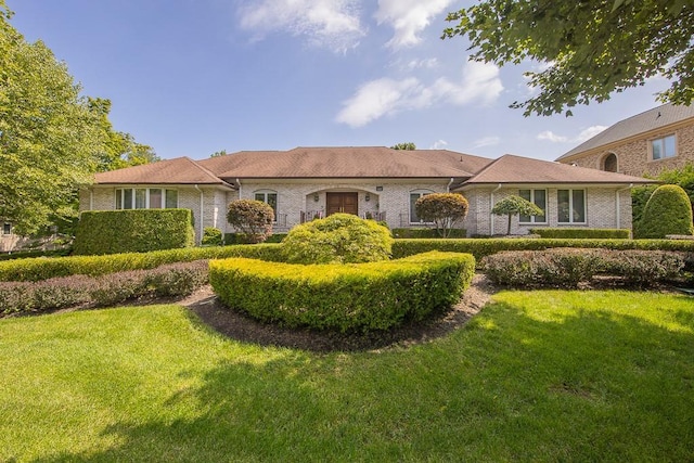 ranch-style home with brick siding and a front yard