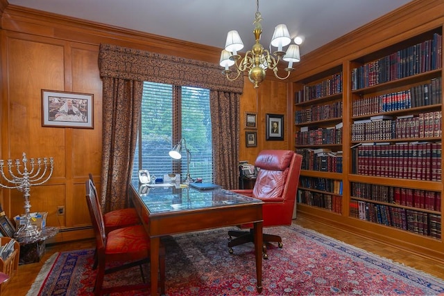 home office with built in shelves, a notable chandelier, ornamental molding, and wood walls