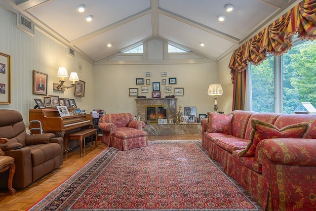 living area with visible vents, a high end fireplace, and lofted ceiling with beams