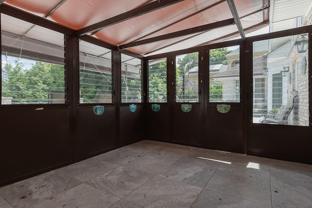 unfurnished sunroom featuring vaulted ceiling